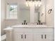 Bathroom featuring double sinks with granite countertop, white cabinets and black hardware at 9630 Turning Wheel Dr, Charlotte, NC 28214