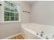 Bright bathroom showcasing a soaking tub with chrome fixtures and natural light from a window at 9630 Turning Wheel Dr, Charlotte, NC 28214
