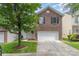Charming brick home featuring an attached garage, manicured lawn, and mature shade tree in the front yard at 9630 Turning Wheel Dr, Charlotte, NC 28214