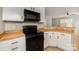Updated kitchen showcasing modern black appliances, wood countertops, and white cabinetry at 9630 Turning Wheel Dr, Charlotte, NC 28214