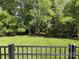 Picturesque backyard view with a well-manicured lawn, mature trees, and a black fence at 11324 Fullerton Place Nw Dr, Huntersville, NC 28078
