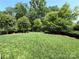 Large backyard with lush green grass, mature trees and a metal fence surrounding the property at 11324 Fullerton Place Nw Dr, Huntersville, NC 28078