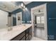 Bathroom with double sink vanity, white tiled shower and open view to bedroom with ceiling fan at 11324 Fullerton Place Nw Dr, Huntersville, NC 28078