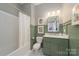 Bathroom featuring a green vanity, subway tiles, and framed botanical prints at 11324 Fullerton Place Nw Dr, Huntersville, NC 28078