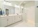 Bathroom featuring marble countertops, dual sinks, and a glass-enclosed shower at 11324 Fullerton Place Nw Dr, Huntersville, NC 28078