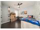 Stylish bedroom with a ceiling fan, desk, Star Wars themed decor, and dark wood floors at 11324 Fullerton Place Nw Dr, Huntersville, NC 28078