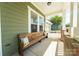 Cozy front porch features a wooden bench with decorative pillows, creating a relaxing outdoor space at 11324 Fullerton Place Nw Dr, Huntersville, NC 28078