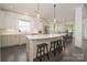 Modern kitchen with white cabinets, quartz countertops, stainless steel appliances, and a breakfast bar at 11324 Fullerton Place Nw Dr, Huntersville, NC 28078