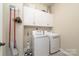 Laundry room featuring a washer and dryer, storage cabinets, and cleaning supplies at 11324 Fullerton Place Nw Dr, Huntersville, NC 28078