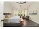Bright main bedroom featuring a ceiling fan, bay windows with seating, and dark wood floors at 11324 Fullerton Place Nw Dr, Huntersville, NC 28078