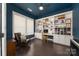 Stylish home office with custom built-in shelves, dark wood floors, and ample natural light at 11324 Fullerton Place Nw Dr, Huntersville, NC 28078