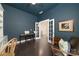 Stylish office featuring French doors, dark hardwood floors, and navy blue accent walls at 11324 Fullerton Place Nw Dr, Huntersville, NC 28078