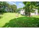 Expansive backyard featuring lush lawn, mature trees, and a patio with an outdoor dining area, perfect for entertaining at 11802 Fox Glen Rd, Charlotte, NC 28269