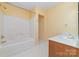 Bright bathroom with a white tiled shower-tub combo and a vanity with a white countertop at 11802 Fox Glen Rd, Charlotte, NC 28269