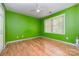 Bright bedroom with vibrant green walls, wood floors and natural light from the window at 11802 Fox Glen Rd, Charlotte, NC 28269