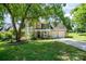 Inviting tan two-story home boasting a well-maintained lawn, two-car garage, and blooming flower beds at 11802 Fox Glen Rd, Charlotte, NC 28269
