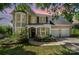 Charming tan home featuring a two-car garage, lush landscaping, and a welcoming front entrance at 11802 Fox Glen Rd, Charlotte, NC 28269