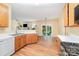 Spacious kitchen with wood cabinets and stainless steel appliances, leading to backyard at 11802 Fox Glen Rd, Charlotte, NC 28269