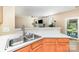 Kitchen sink overlooking adjacent sitting area and access to outdoor patio at 11802 Fox Glen Rd, Charlotte, NC 28269