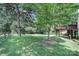 Large backyard with a wooden deck, screened porch, lush lawn, and mature trees at 1201 Beckford Glen Dr, Waxhaw, NC 28173