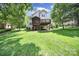 Lush backyard with a deck, screened porch, and expansive green lawn, perfect for outdoor activities at 1201 Beckford Glen Dr, Waxhaw, NC 28173