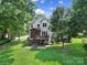 Beautiful backyard featuring a deck, a screened porch, a well-maintained lawn, and mature trees at 1201 Beckford Glen Dr, Waxhaw, NC 28173