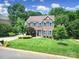 Charming two-story brick home with blue shutters and a well-manicured lawn in a leafy neighborhood at 1201 Beckford Glen Dr, Waxhaw, NC 28173