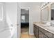 Bathroom boasts double sinks, marble countertop, modern fixtures, and bathtub view into bedroom at 13528 Philip Michael Rd, Huntersville, NC 28078