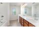 Bright bathroom showcasing a dual sink vanity, large mirror, and a bathtub-shower combo at 15524 Scholastic Dr, Charlotte, NC 28277