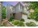 A two-story home with gray siding and brick accents, enhanced by lush landscaping and a well-manicured lawn at 15524 Scholastic Dr, Charlotte, NC 28277