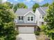 A two-story home with gray siding, complemented by a brick-clad two-car garage and a concrete driveway at 15524 Scholastic Dr, Charlotte, NC 28277