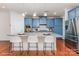 The modern kitchen has blue cabinets, stainless steel appliances, and a large island with a stone countertop at 15524 Scholastic Dr, Charlotte, NC 28277