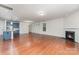 A spacious living room with hardwood floors, a fireplace, and an open layout that connects to the modern kitchen at 15524 Scholastic Dr, Charlotte, NC 28277