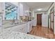 Well-lit kitchen featuring white cabinets, granite countertops, and access to the laundry area at 158 Jane Sowers Rd, Statesville, NC 28625