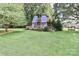 Charming custom playhouse with a unique design and lovely landscaping in the backyard at 158 Jane Sowers Rd, Statesville, NC 28625