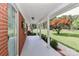 Covered porch view of a brick home, featuring white columns and mature landscaping at 158 Jane Sowers Rd, Statesville, NC 28625