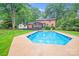 Inviting backyard featuring a large swimming pool, patio, and lush greenery for outdoor enjoyment at 16512 Kimbolten Dr, Huntersville, NC 28078