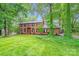 Charming brick home with lush green lawn and mature trees, creating a serene and inviting curb appeal at 16512 Kimbolten Dr, Huntersville, NC 28078