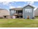 Features an outdoor fireplace, green lawn, gray siding, covered grill, walkout basement, and a screened in porch at 1663 Tranquility Blvd, Lancaster, SC 29720