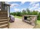 Paved patio features a modern brick fireplace, a grill, and lush landscaping at 1663 Tranquility Blvd, Lancaster, SC 29720