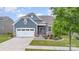 Charming exterior with blue siding, stone accents, manicured lawn, and two car garage at 1663 Tranquility Blvd, Lancaster, SC 29720