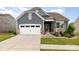 Charming exterior with blue siding, stone accents, manicured lawn, and two car garage at 1663 Tranquility Blvd, Lancaster, SC 29720