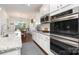 Close-up of kitchen details, including granite countertops, stainless steel oven, and white cabinetry at 1663 Tranquility Blvd, Lancaster, SC 29720