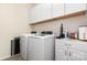 Bright laundry room with white washer, dryer, cabinets, and countertop for folding at 1663 Tranquility Blvd, Lancaster, SC 29720