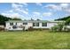 Charming single-story home with a green roof and shutters, complemented by a lush green lawn and blooming flower bushes at 1720 Lowe Dr, Catawba, NC 28609