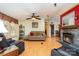 Spacious living room featuring hardwood floors, a ceiling fan, stone fireplace, and comfortable sofa at 1720 Lowe Dr, Catawba, NC 28609