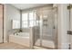 Bright bathroom featuring a separate tub and glass shower with tiled walls, seat, and shampoo nook at 173 Morgans Branch Rd, Belmont, NC 28012
