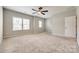 Spacious bedroom featuring a ceiling fan, plush carpet, and natural light from two windows at 173 Morgans Branch Rd, Belmont, NC 28012