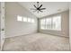 This bedroom features a vaulted ceiling, ceiling fan, carpet floors and lots of natural light from multiple windows at 173 Morgans Branch Rd, Belmont, NC 28012