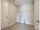 This laundry room has tile floors, neutral walls and a wire shelf for storage at 173 Morgans Branch Rd, Belmont, NC 28012